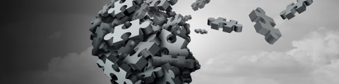 grey scale visual of jigsaw pieces coming together to form brain and head